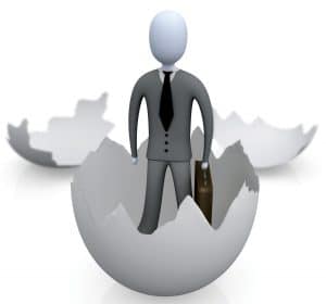 Royalty-free 3d generated business clipart picture graphic of a businessman carrying a briefcase and coming out of an eggshell.